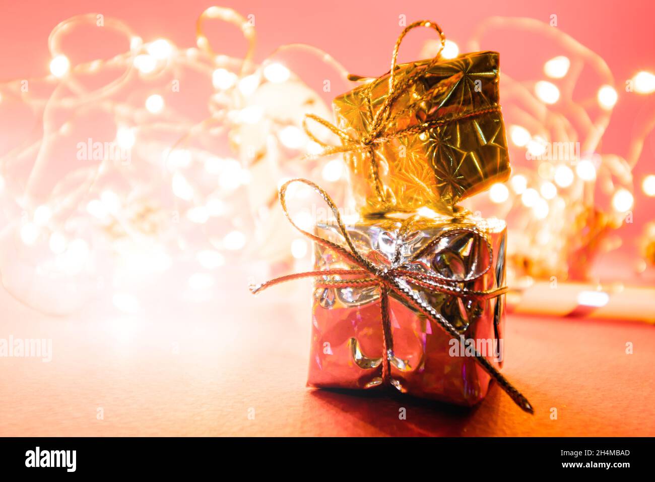 Christmas background with lights and lanterns with gifts in the foreground. Stock Photo