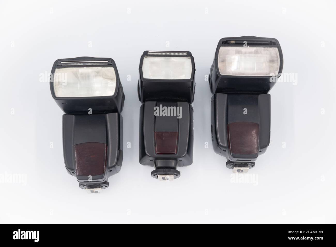 Three Black external flashes on a white background. Used for indoor and outdoor lighting. Copy location. Photo technology concept Stock Photo