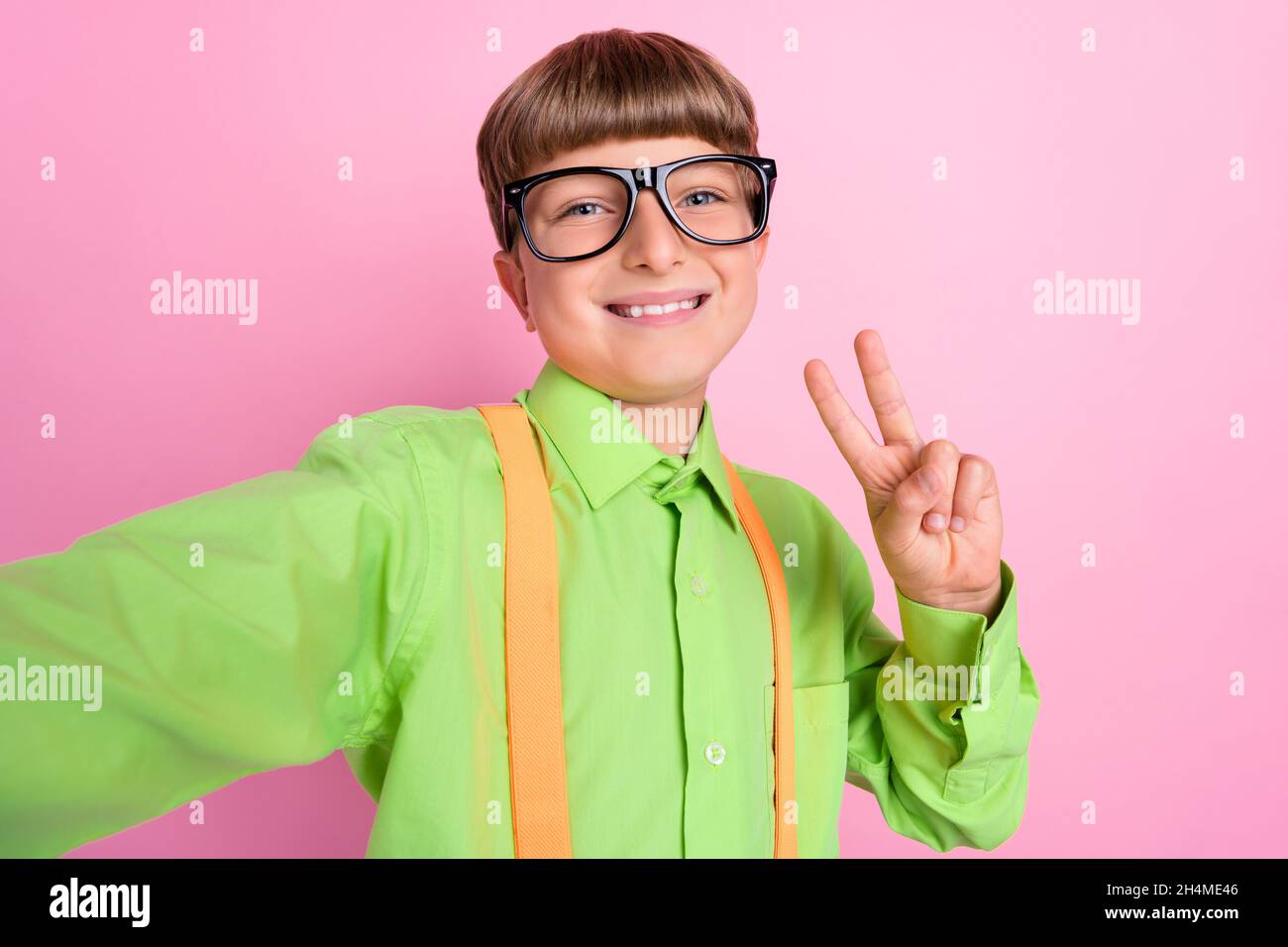 Photo of young cheerful preteen stylish boy shoot selfie show peace cool v-sign isolated over pink color background Stock Photo