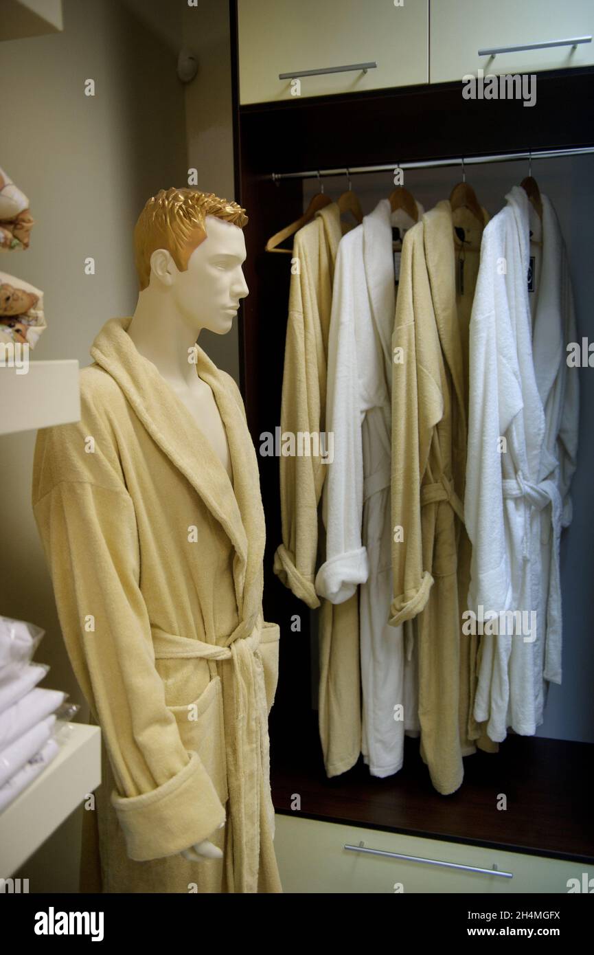 A picture of a lot of dressing gowns on wooden hangers in a store and a