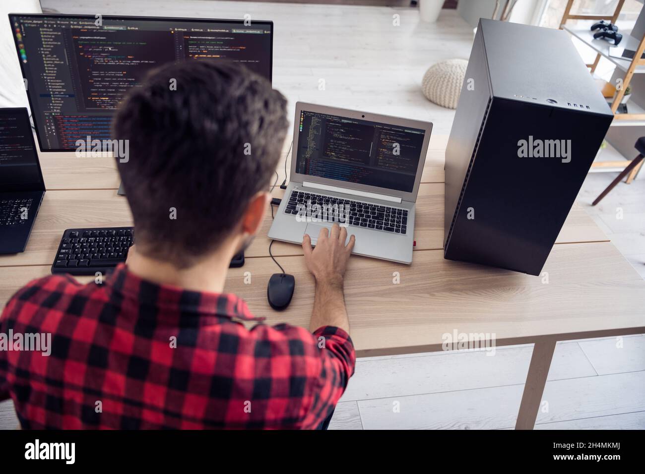 Back rear spine view photo of young man work computer write code system security indoors inside office workplace Stock Photo