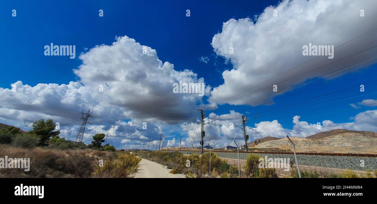 High voltage transmission towers under a blue sky with clouds Stock ...