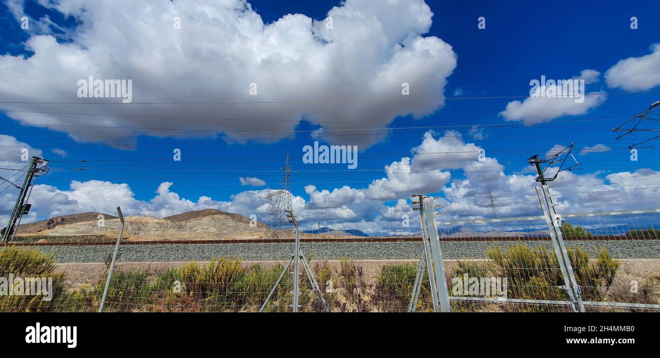 High voltage transmission towers under a blue sky with clouds Stock ...