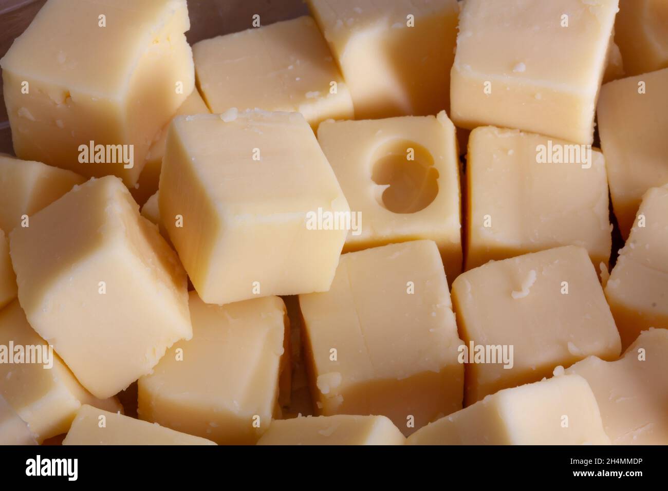 Closeup shot of a pile of square-cut cheese pieces Stock Photo