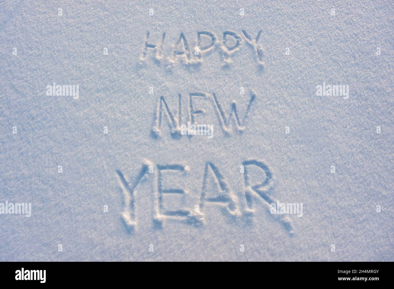 Happy New Year text draw on snow for holiday card Stock Photo