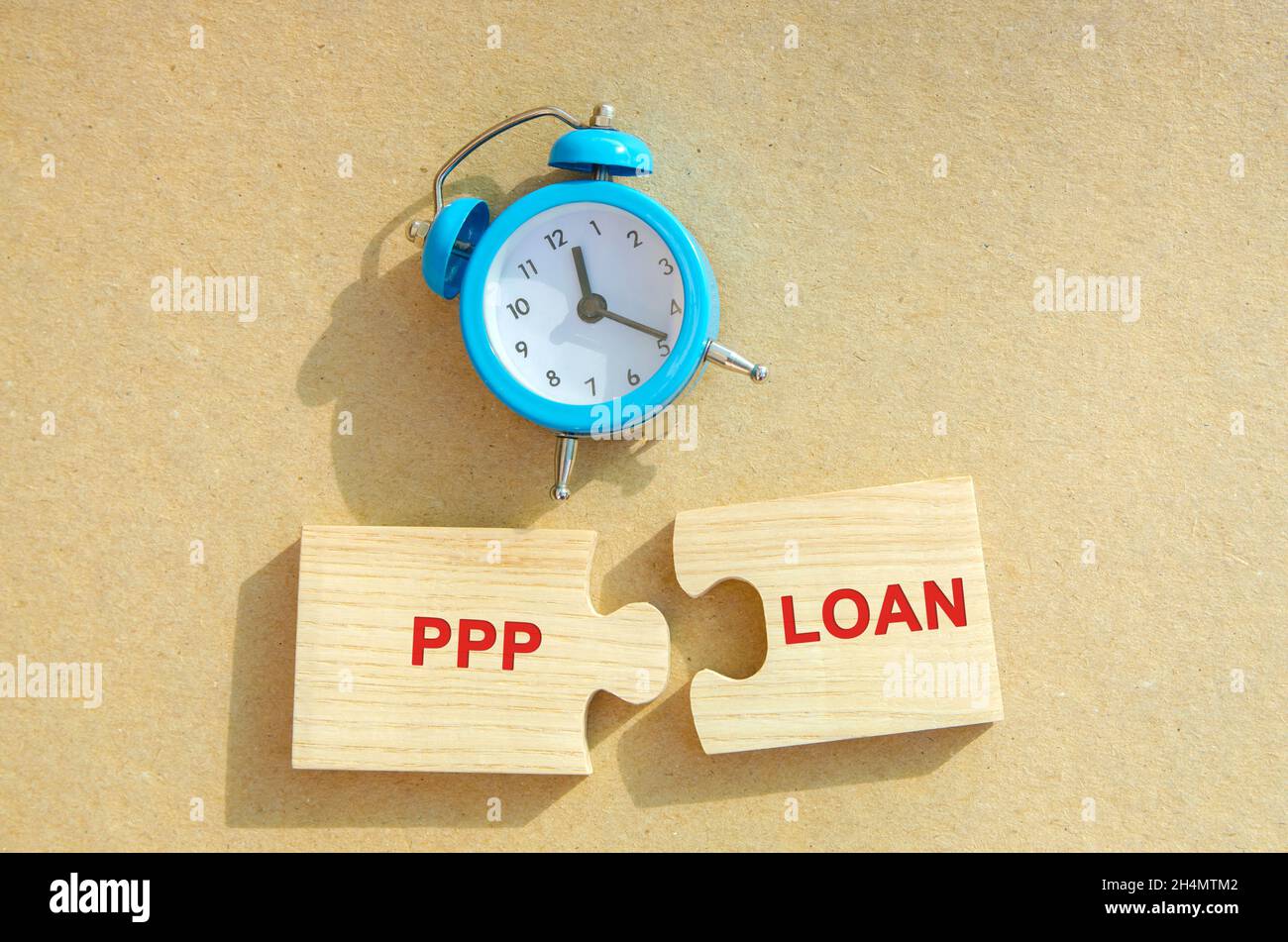 Puzzles with words PPP loan and alarm clock. Paycheck Protection Program. Loan designed to provide a direct incentive for small businesses to keep the Stock Photo