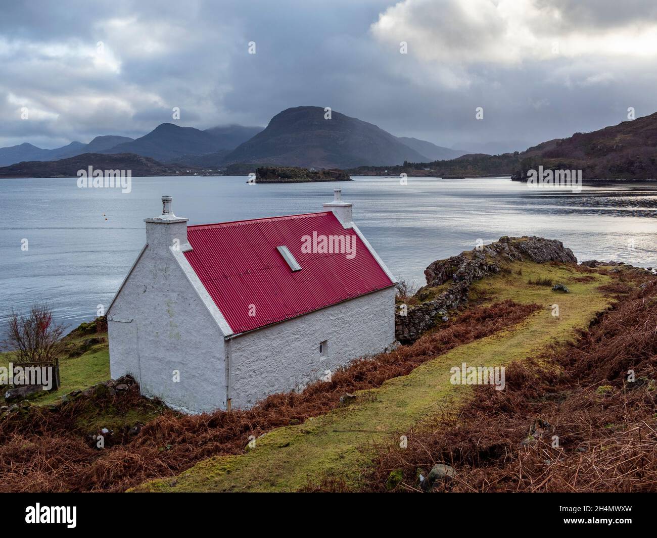 White stone cottage with red roof by Loch Shieldaig on the NC500 route, Wester Ross, Scotland Stock Photo