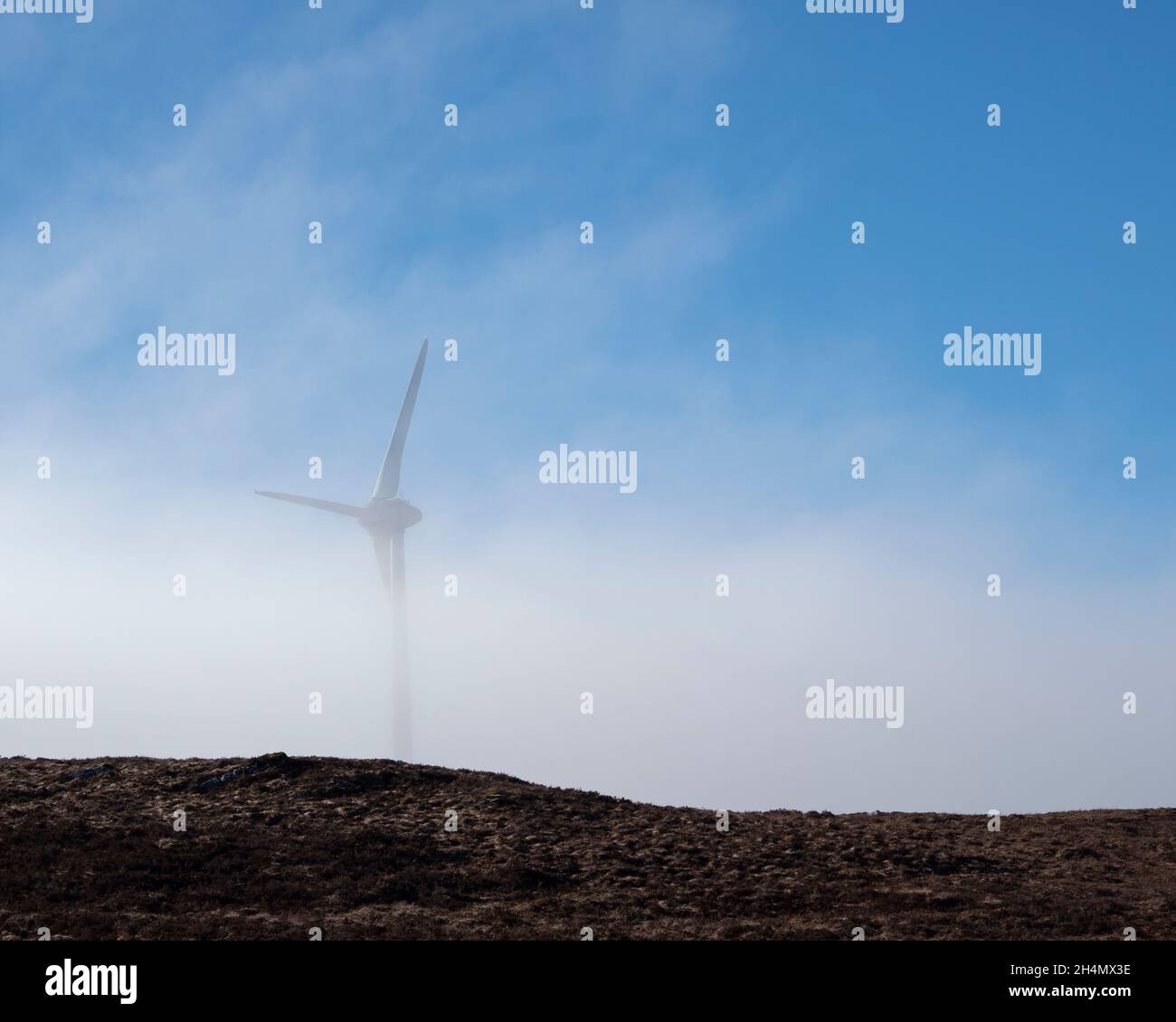 Wind turbine emerging from the mist. Corrimony Wind Farm, Highland, Scotland Stock Photo