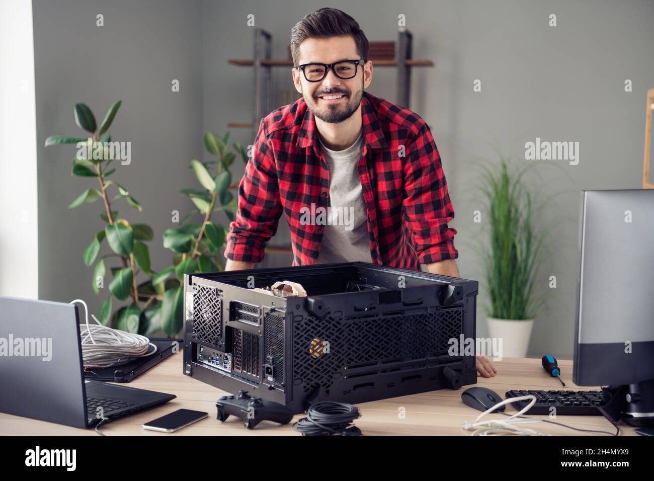 Portrait of attractive skilled cheerful trendy guy upgrading processor ...