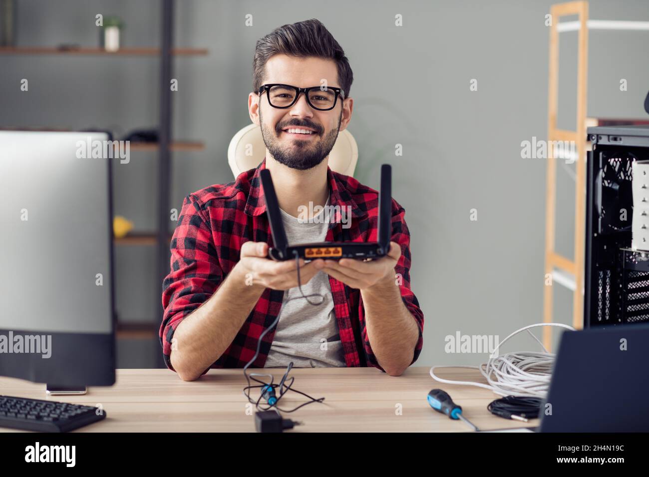 Portrait of attractive cheerful skilled trendy guy fixing repairing rout line service at office work place station indoor Stock Photo