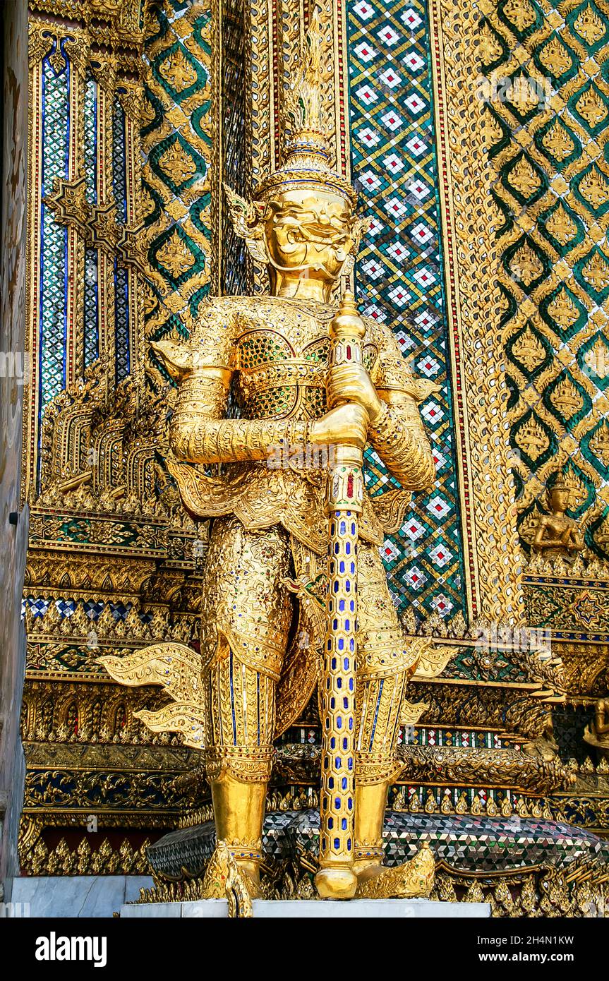 Golden guardian statue stands at the entrance to Temple of the Emerald Buddha, Wat Phra Kaew, The Grand Palace.     Bangkok, Thailand Stock Photo