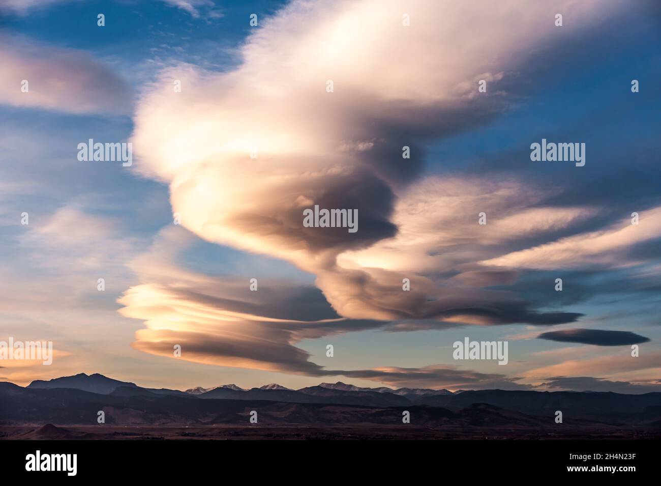 A cloud that looks like a spaceship hangs over the continental divide in Colorado Stock Photo