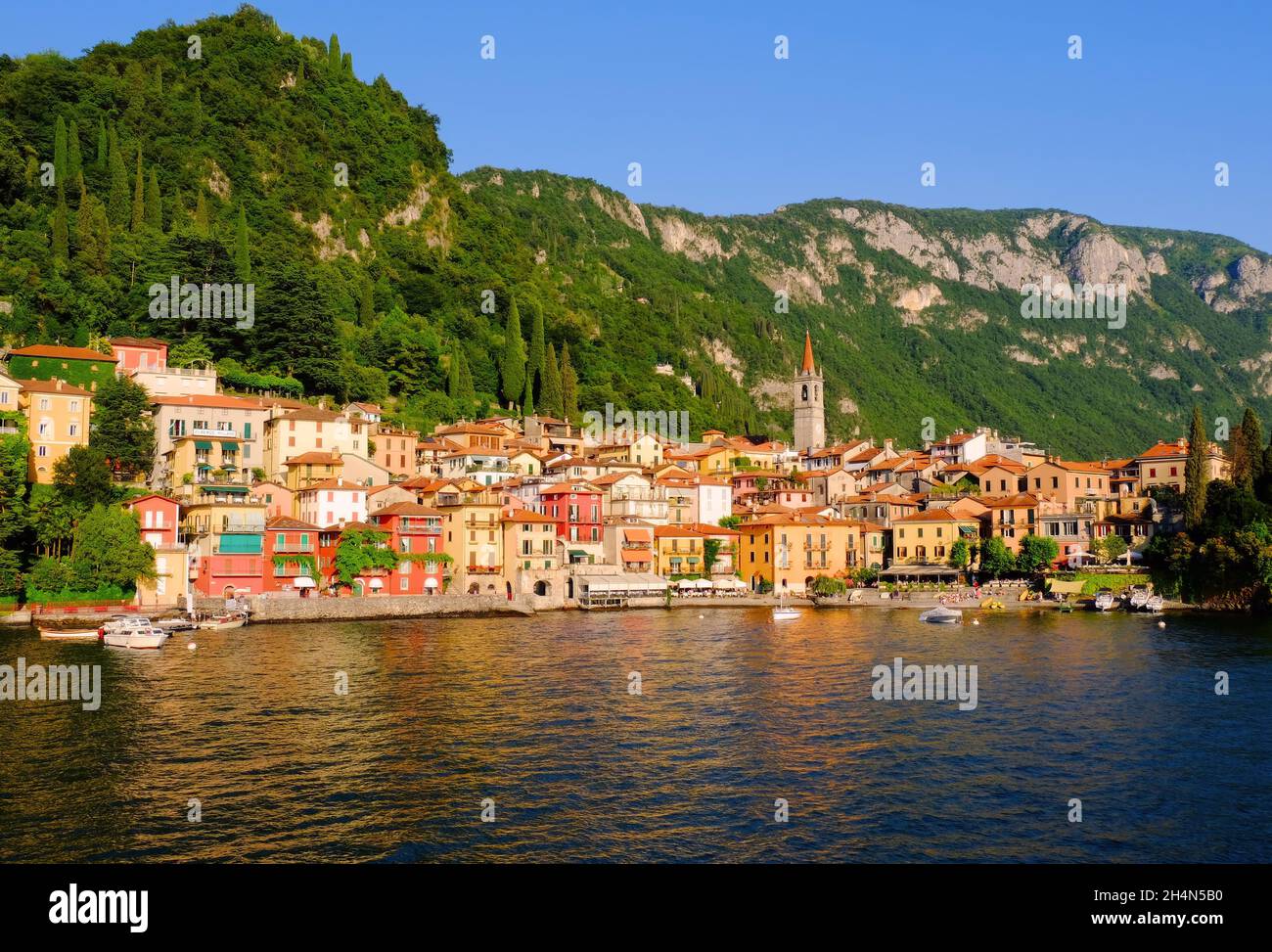 Colourful town of Varenna with bell tower of St George Church soon before sunset on Lake Como, Italian Lakes, Italy Stock Photo