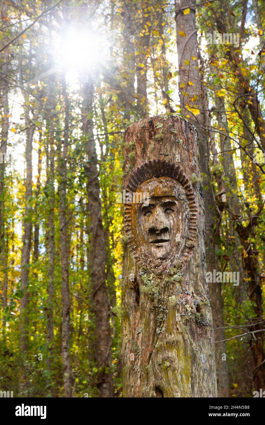 Carved masks in locust poles by Davy Arch.  John Campbell Folk School campus, Rivercane Trail.  Brasstown, North Carolina. Stock Photo