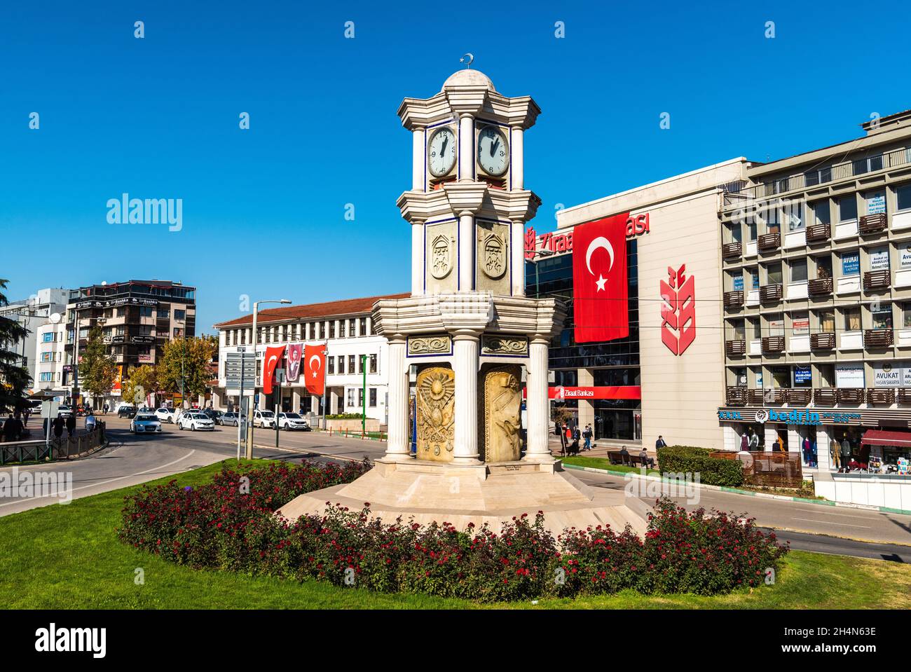 Bursa, Turkey – November 10, 2020. Clock tower in Ataturk caddesi avenue in Bursa, Turkey. View with surrounding buildings on a sunny day. Stock Photo