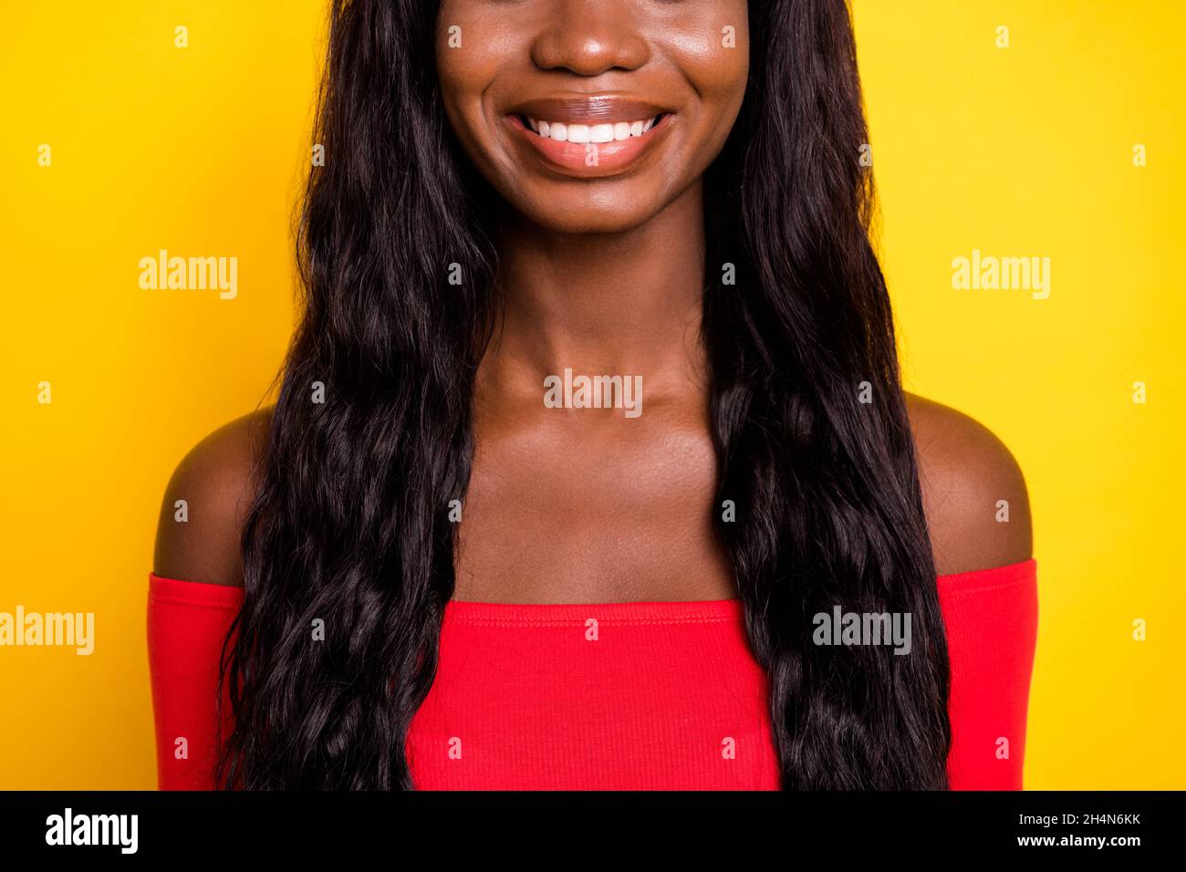 Cropped photo of charming pretty dark skin lady neck wear off-shoulders top hsmiling isolated yellow color background Stock Photo