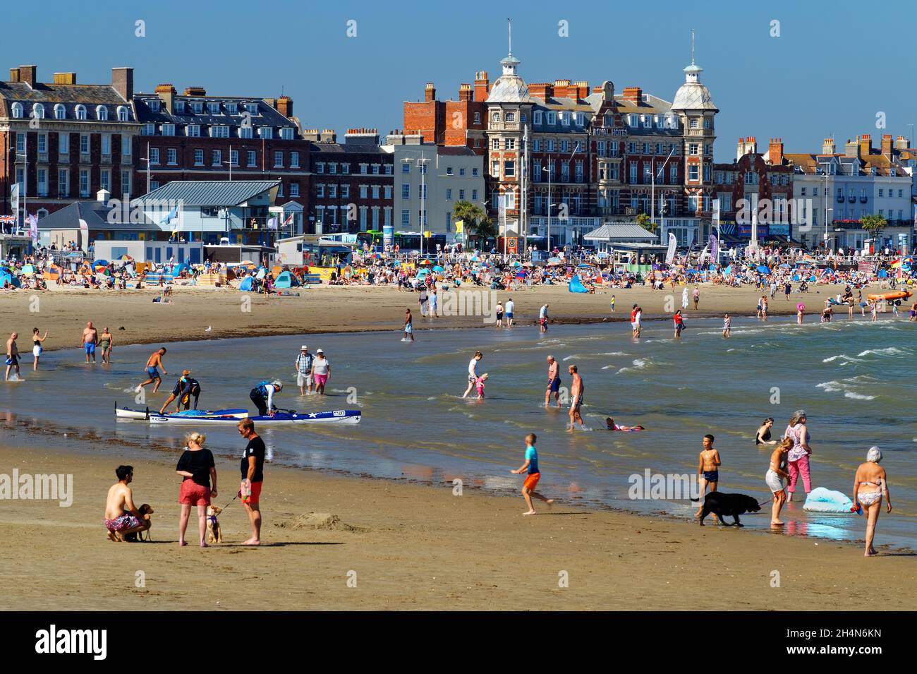 UK, Dorset, Weymouth, Busy beach during summer next to the Esplanade and Royal Hotel. Stock Photo