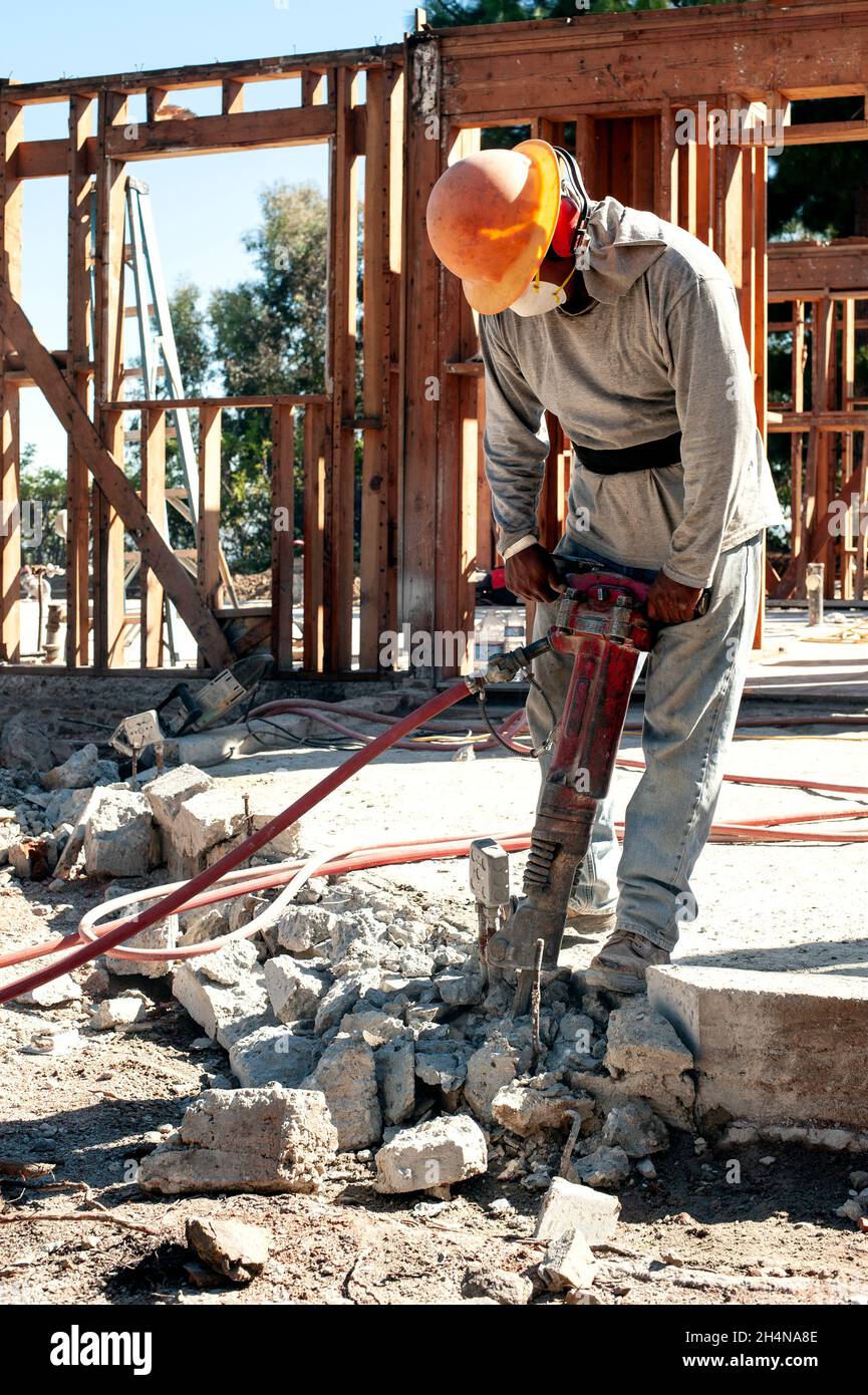 Construction worker using a jackhammer to remove a concrete slab Stock
