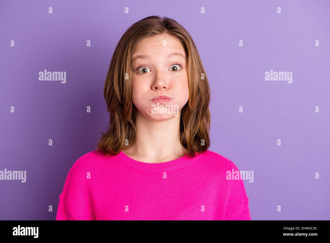 Photo of funky cute cheerful teenage girl hold breath cheeks funny face isolated on violet color background Stock Photo