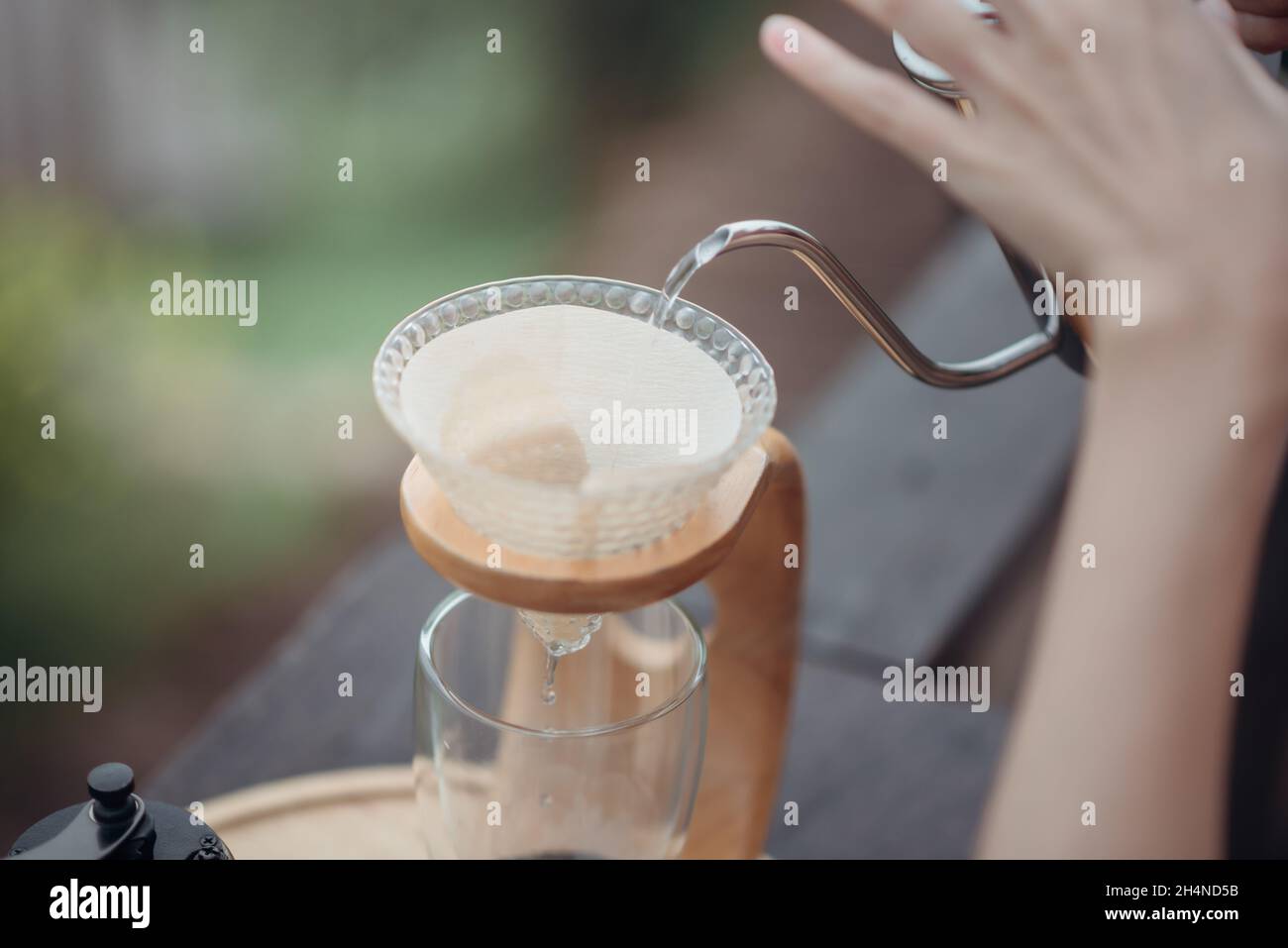 Hand drip coffee, Barista pouring the hot water in the filter before