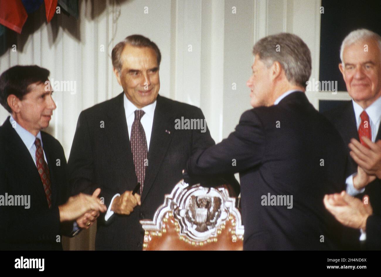 United States President Bill Clinton, center right, greets US Trade Representative Mickey Kantor, left, incoming US Senate Majority Leader Bob Dole (Republican of Kansas), center left, and Speaker of the US House of Representatives Tom Foley (Democrat of Washington) following his signing of the multinational GATT Treaty at the Organization of American States Building in Washington, DC on Thursday, December 8, 1994.Credit: Ron Sachs / CNP / MediaPunch Stock Photo