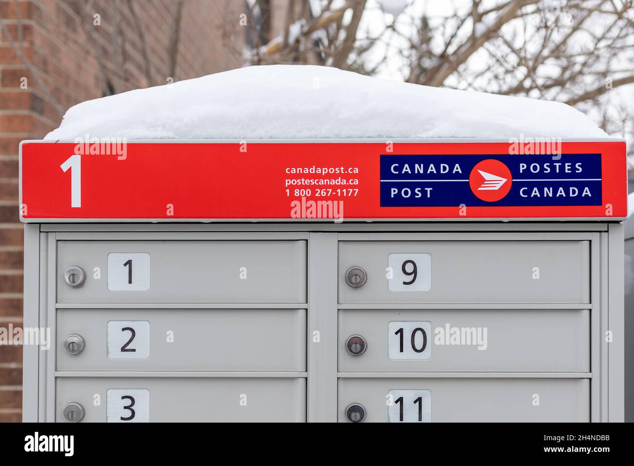Canada Post mailboxes with red sign in English and French near house in winter Stock Photo Alamy