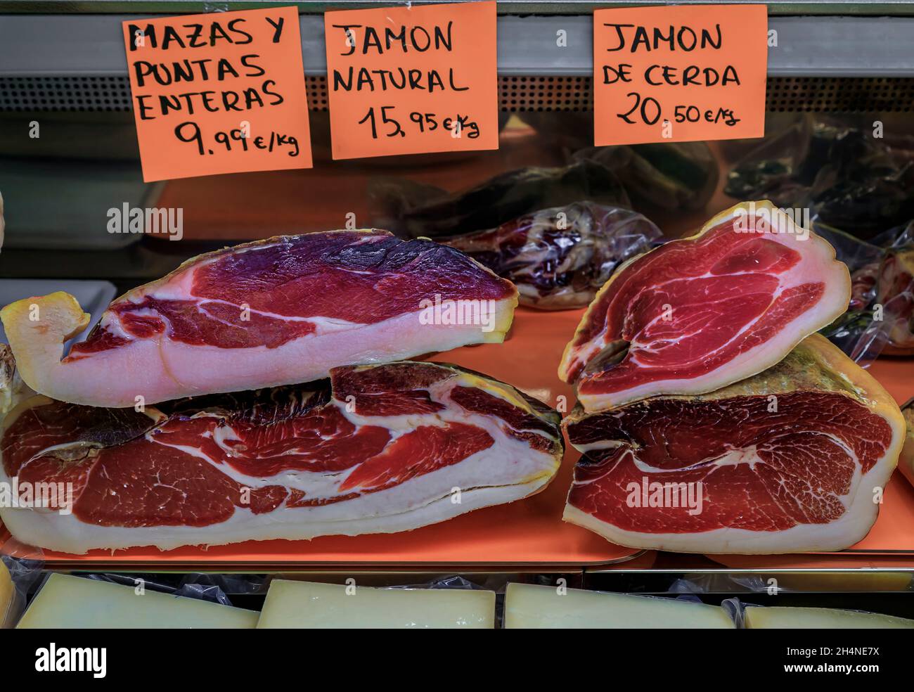 Carved pieces of Spanish jamon iberico ham with price tags above for sale at a local butcher
