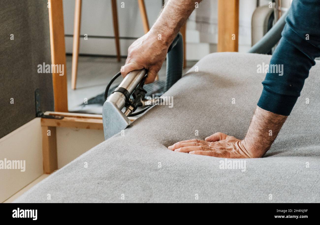 Professional cleaning service deep cleaning sofa at home. Hand holding