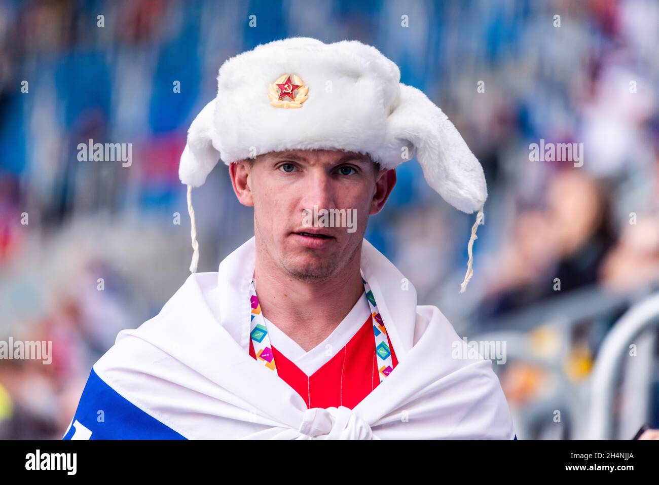 Saint Petersburg, Russia – June 16, 2021. Russian fan wearing white ear-flaps hat at EURO 2020 match Finland vs Russia (0-1) Stock Photo