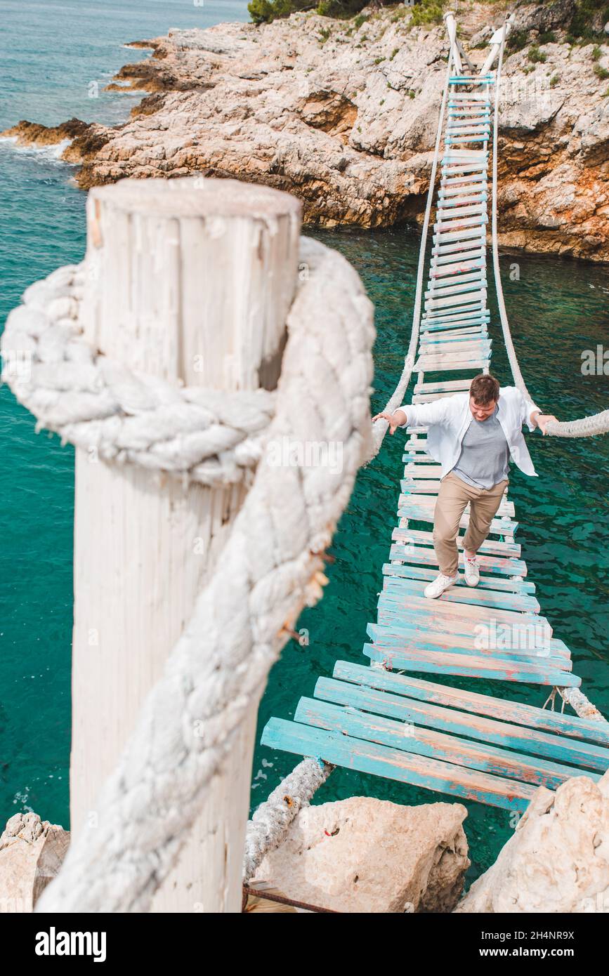man walking by suspension bridge summer time copy space Stock Photo - Alamy