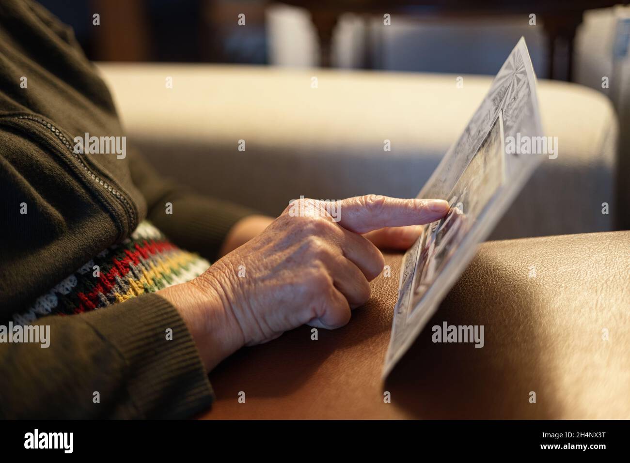 Old woman looking at vintage family photo Stock Photo