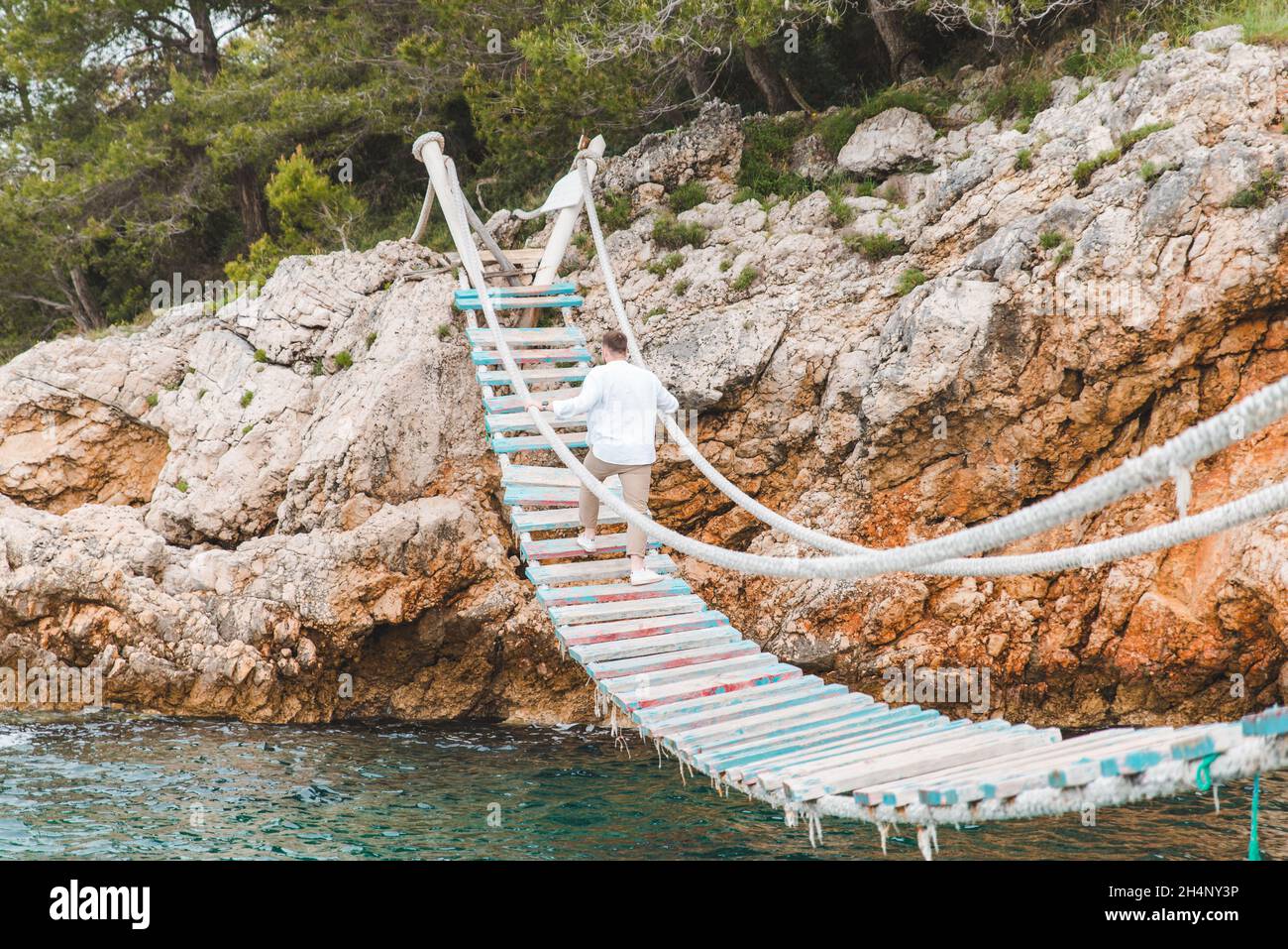 man walking by suspension bridge summer time copy space Stock Photo - Alamy