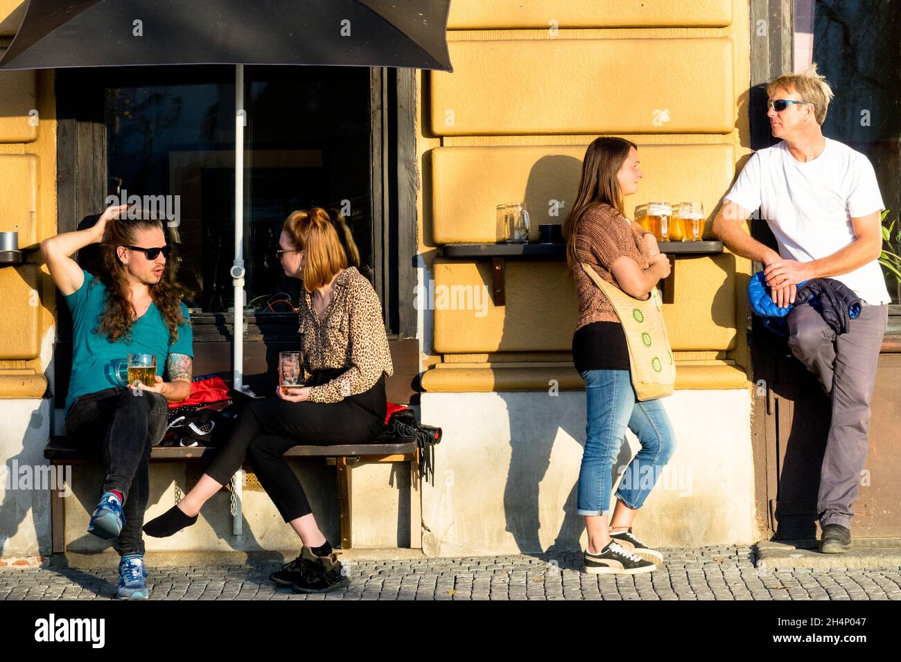 Tourists in Prague drinking beer outside a bar young friends drink Stock Photo
