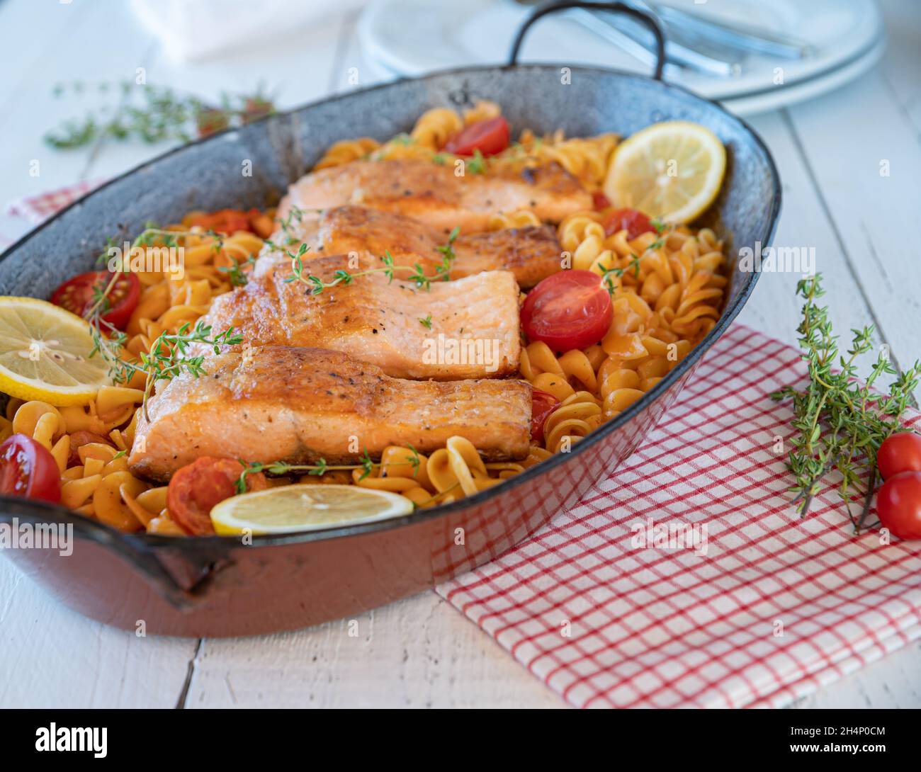 Delicious family meal with fried salmon and pasta in a delicious tomato sauce. Stock Photo