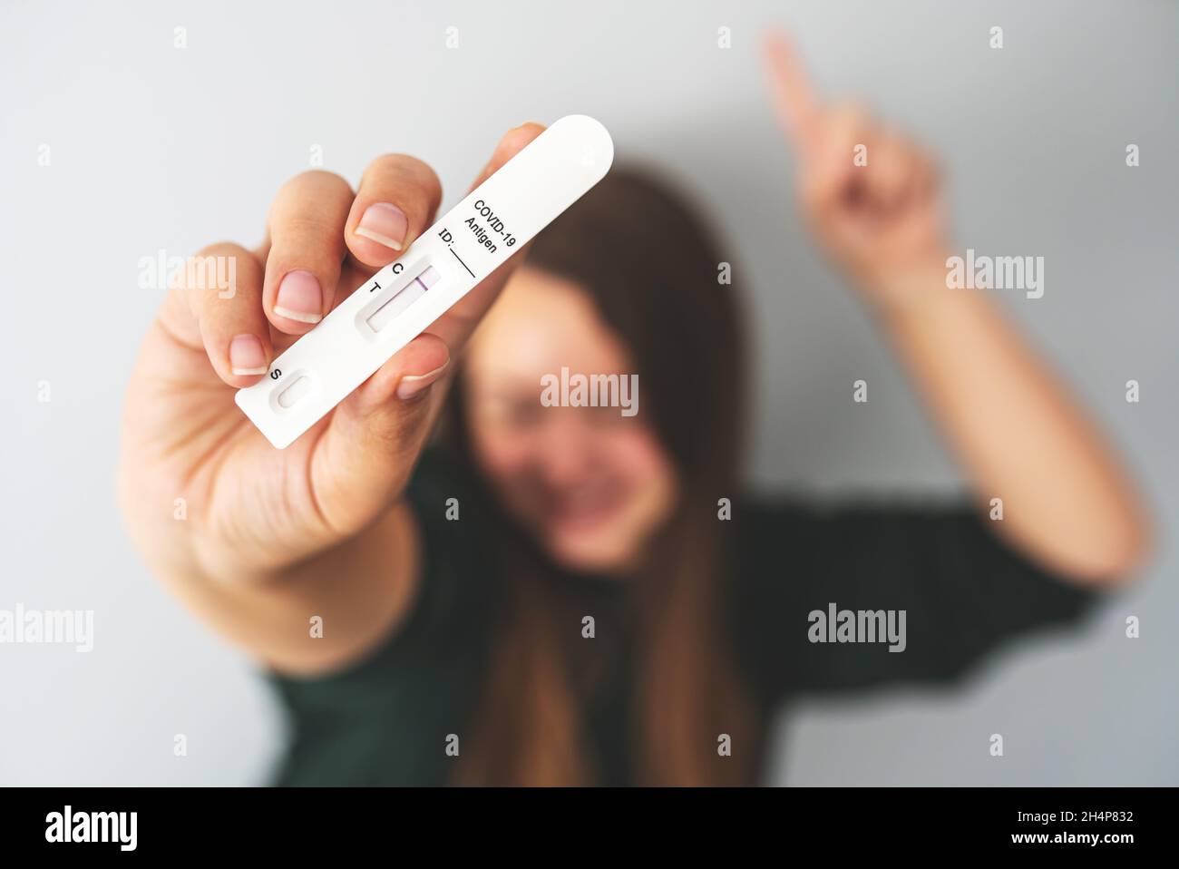 Negative rapid antigen COVID-19 test in hand of unrecognizable blurred person. Happy woman shows her test result. Travel during the coronavirus pandemic, avoid quarantine, new normal concept. Stock Photo