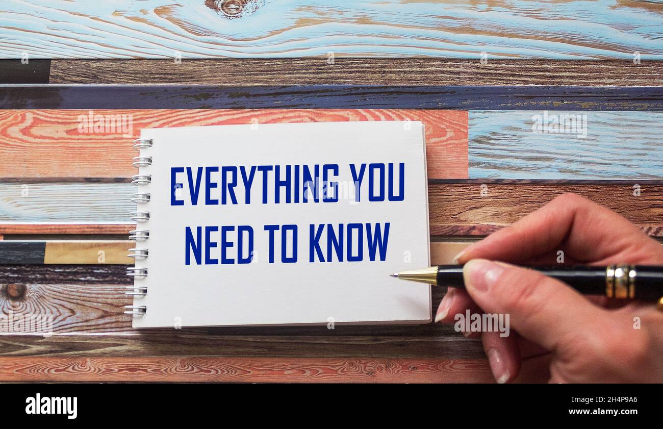 Everything you need to know. Motivational quote is written by a stiff hand on a notebook. Striped background. Stock Photo