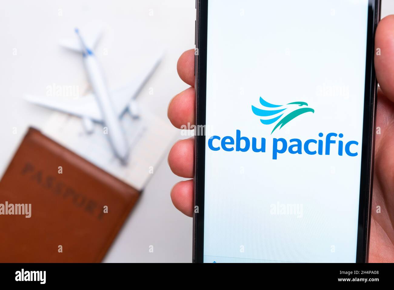 Cebu Pacific airlines logo on the screen of smartphone on the background of passport, ticket and plane, September 2021, San Francisco, USA Stock Photo