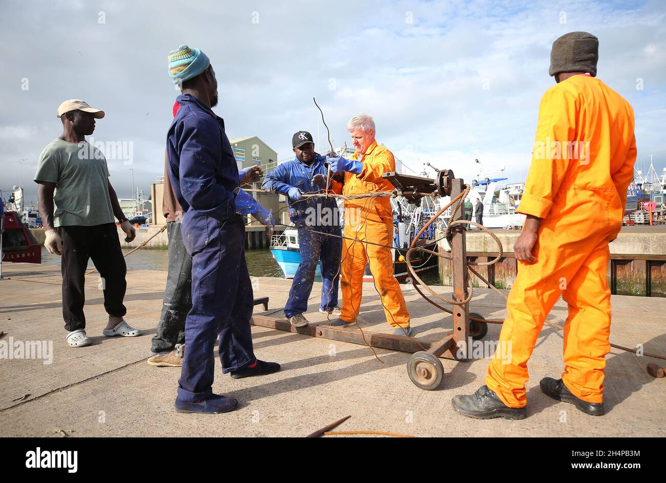 Fishing men prepare their nets and boats before heading out to sea from Kilkeel Harbour in Co. Down, Northern Ireland Stock Photo