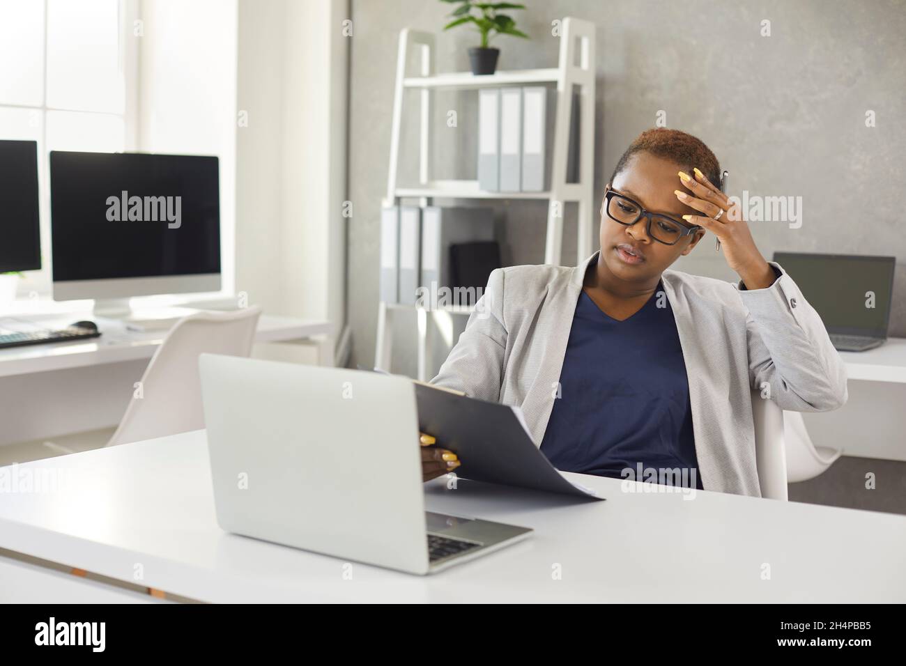 Unhappy African American businesswoman stressed by bad news Stock Photo