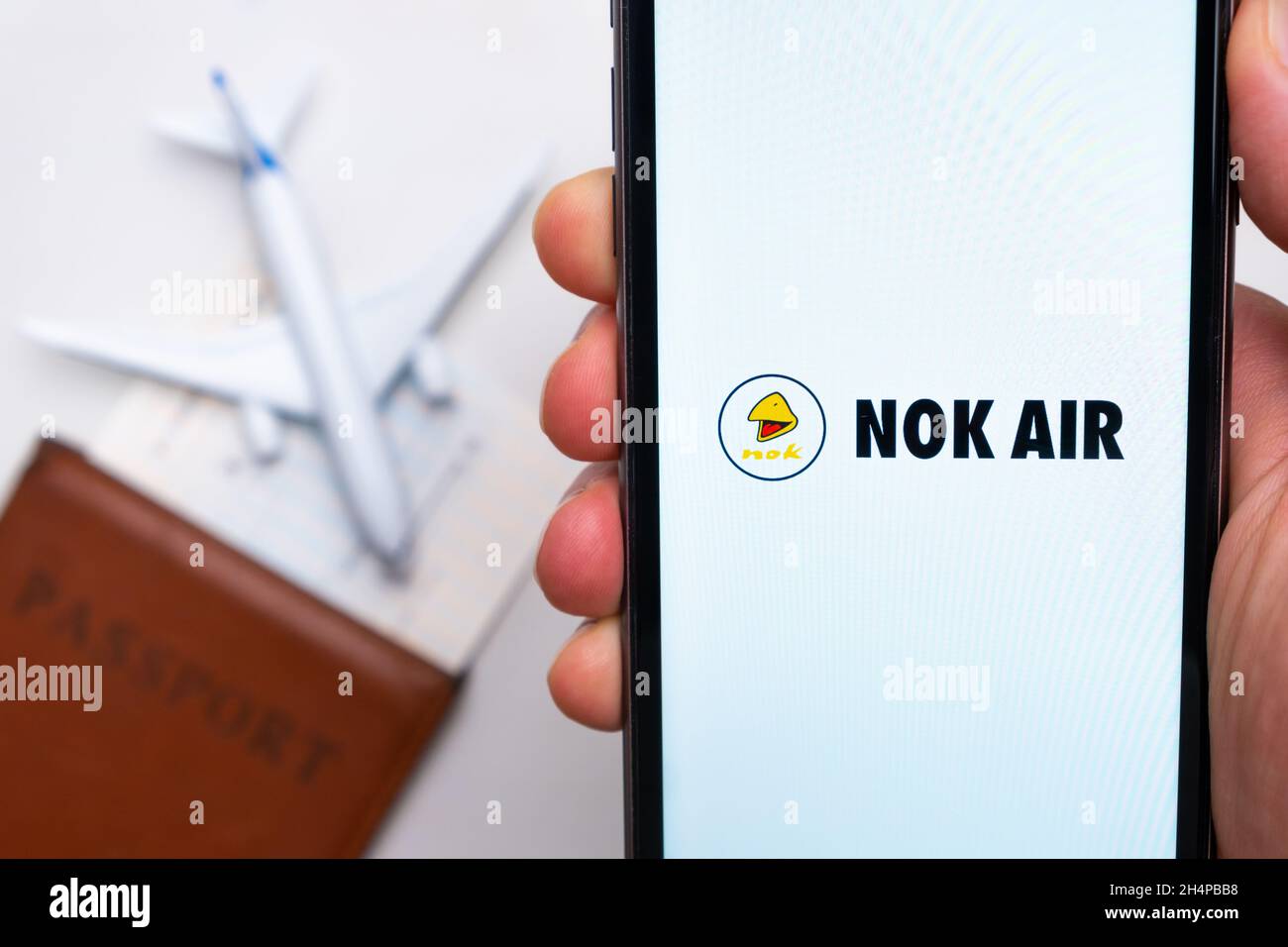 NOK AIR airlines company app or logo displayed on a mobile phone with passport, boarding pass and plane on the background, September 2021, San Stock Photo