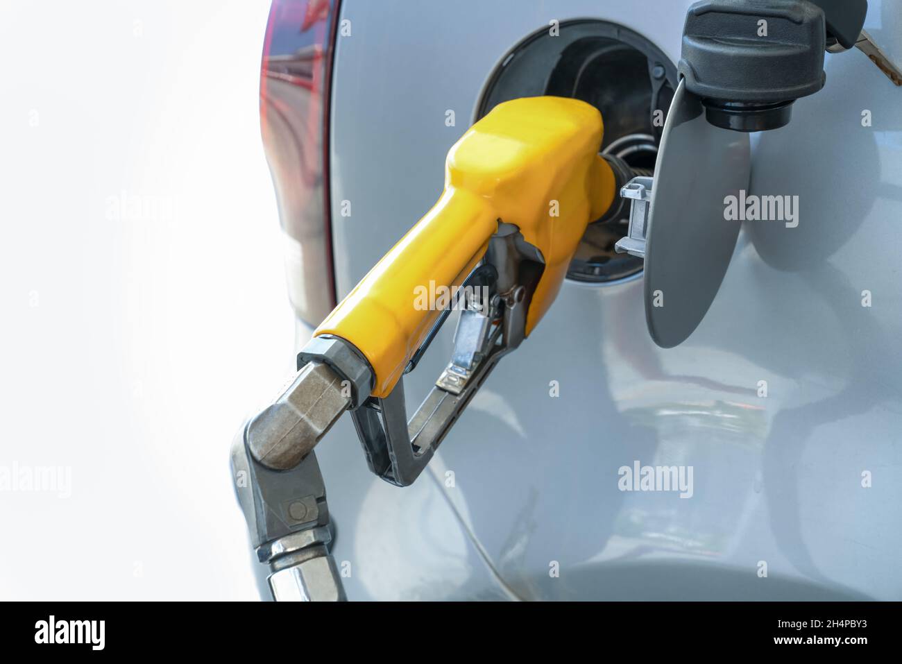 Refueling gun in tank of car, while refueling car with gasoline fuel, at gas station concept of service and fuel. Close-up. Stock Photo