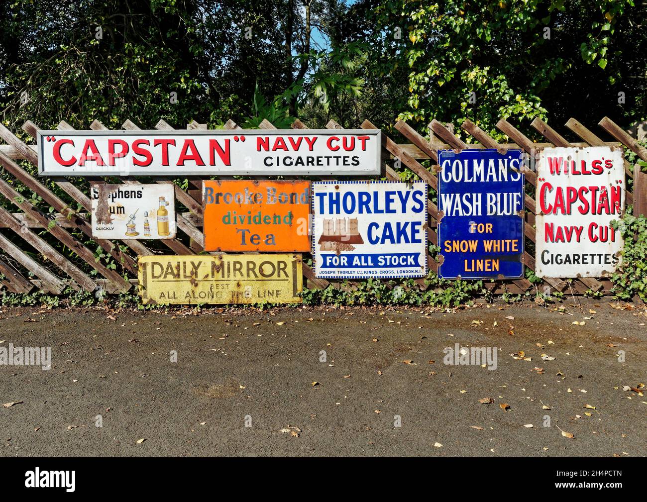 Enamel advertising signs from the 1930's and earlier on the fence by the reconstructed Rowley station at the Beamish Museum. Stock Photo