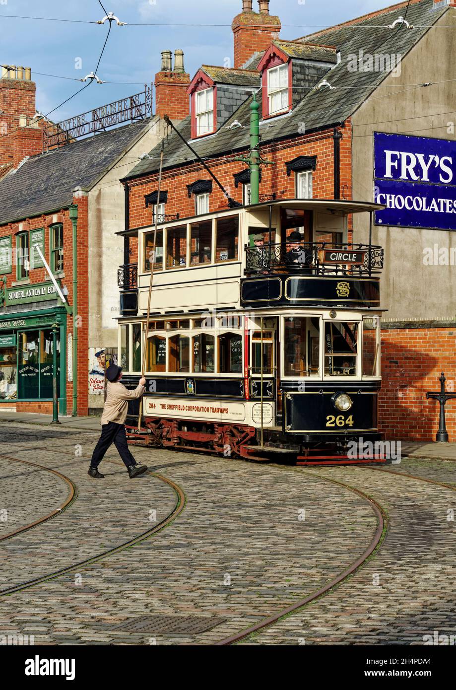 Restored Sheffield tram car recreates a 1900's street scene with people in period costume ain the town area of Beamish Museum, County Durham. Stock Photo