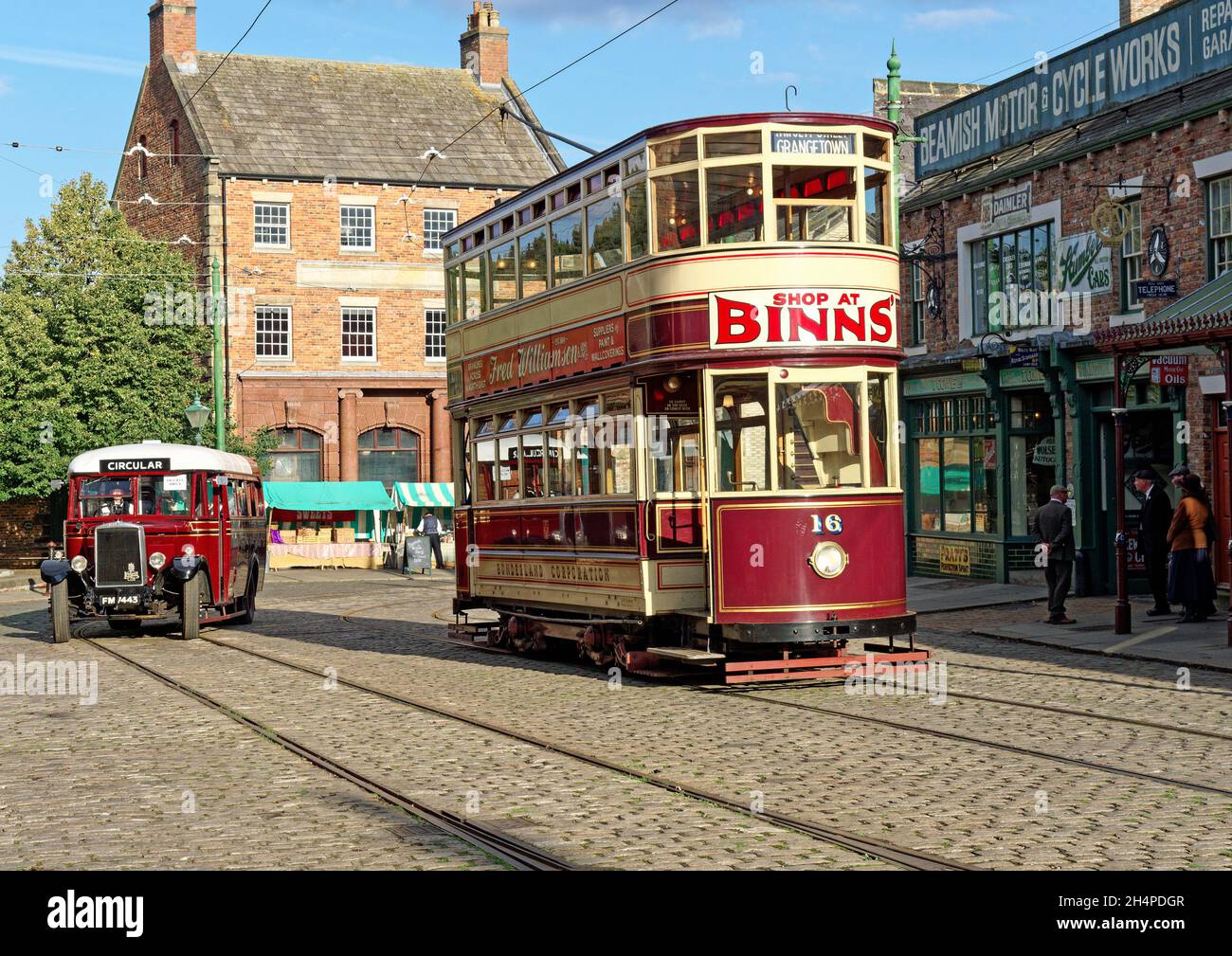 Former Sunderalnd tram and a Leyland Cub bus recreate a1930 street scene in the 1900's town at Beamish Museum, Stock Photo