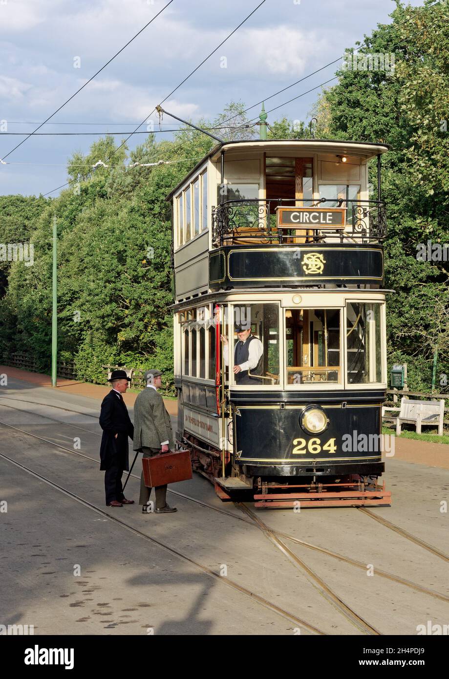 Restored former Sheffield tram car at a stop on the tramway system at Beamish Museum with passengers in period costume. Stock Photo