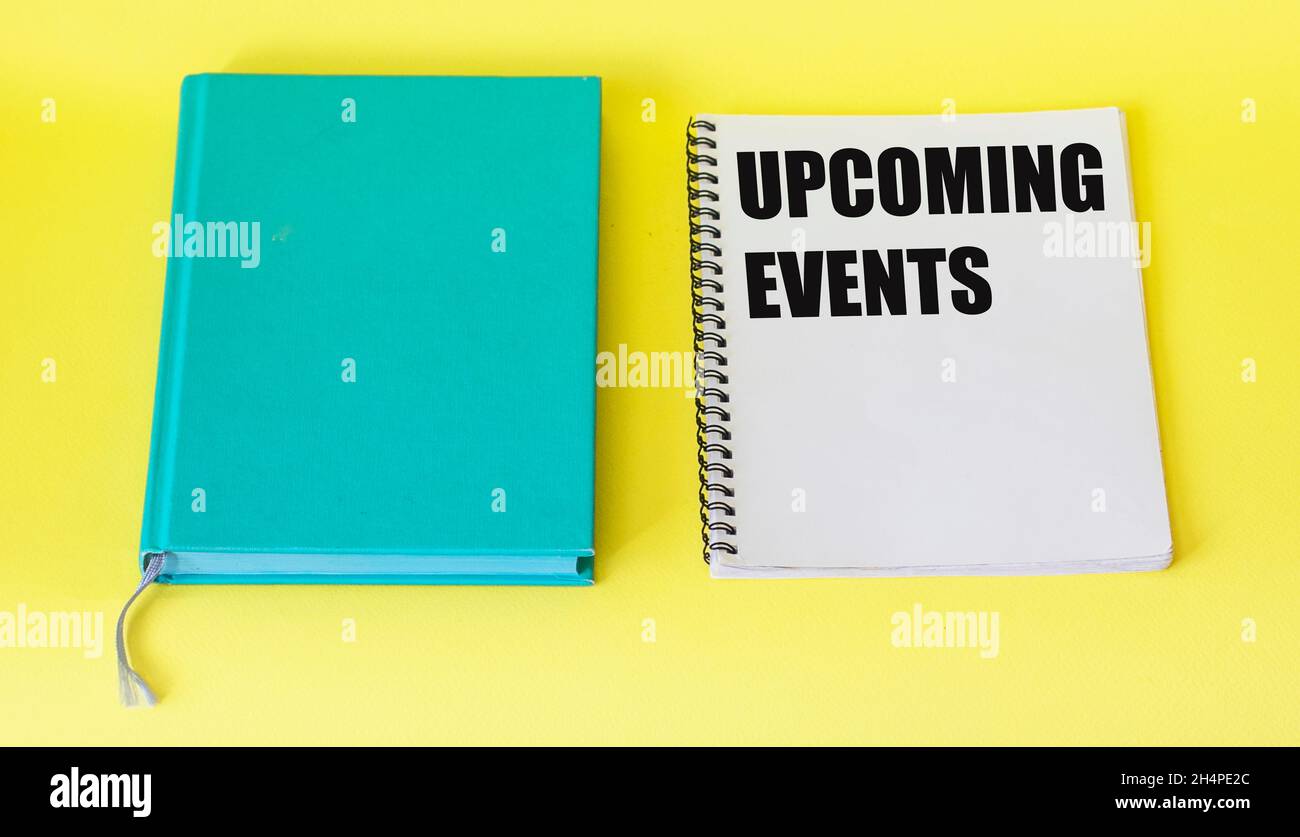 Message upcoming events concept on notebook with pen and notepad on yellow table Stock Photo