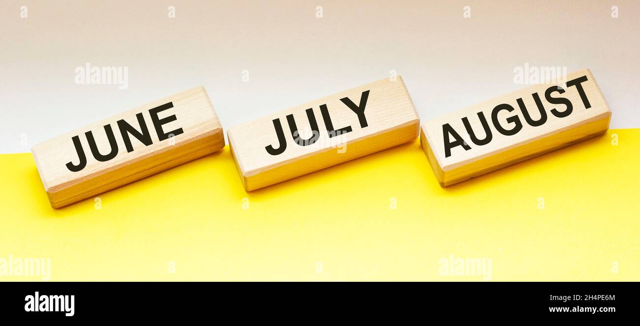 on wooden blocks text june july and august Stock Photo