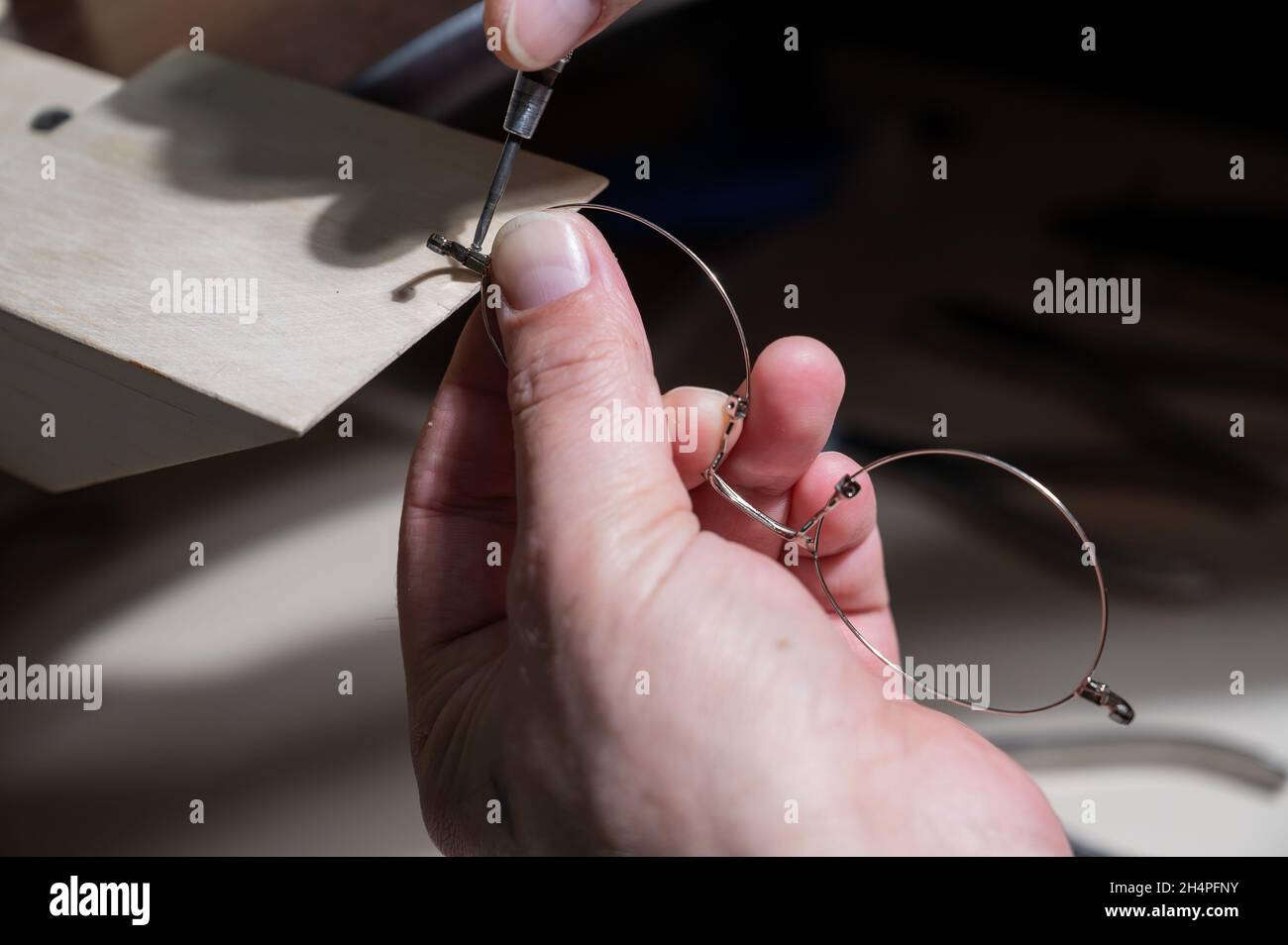 Optical technician fixing glasses. Closeup of male hands with