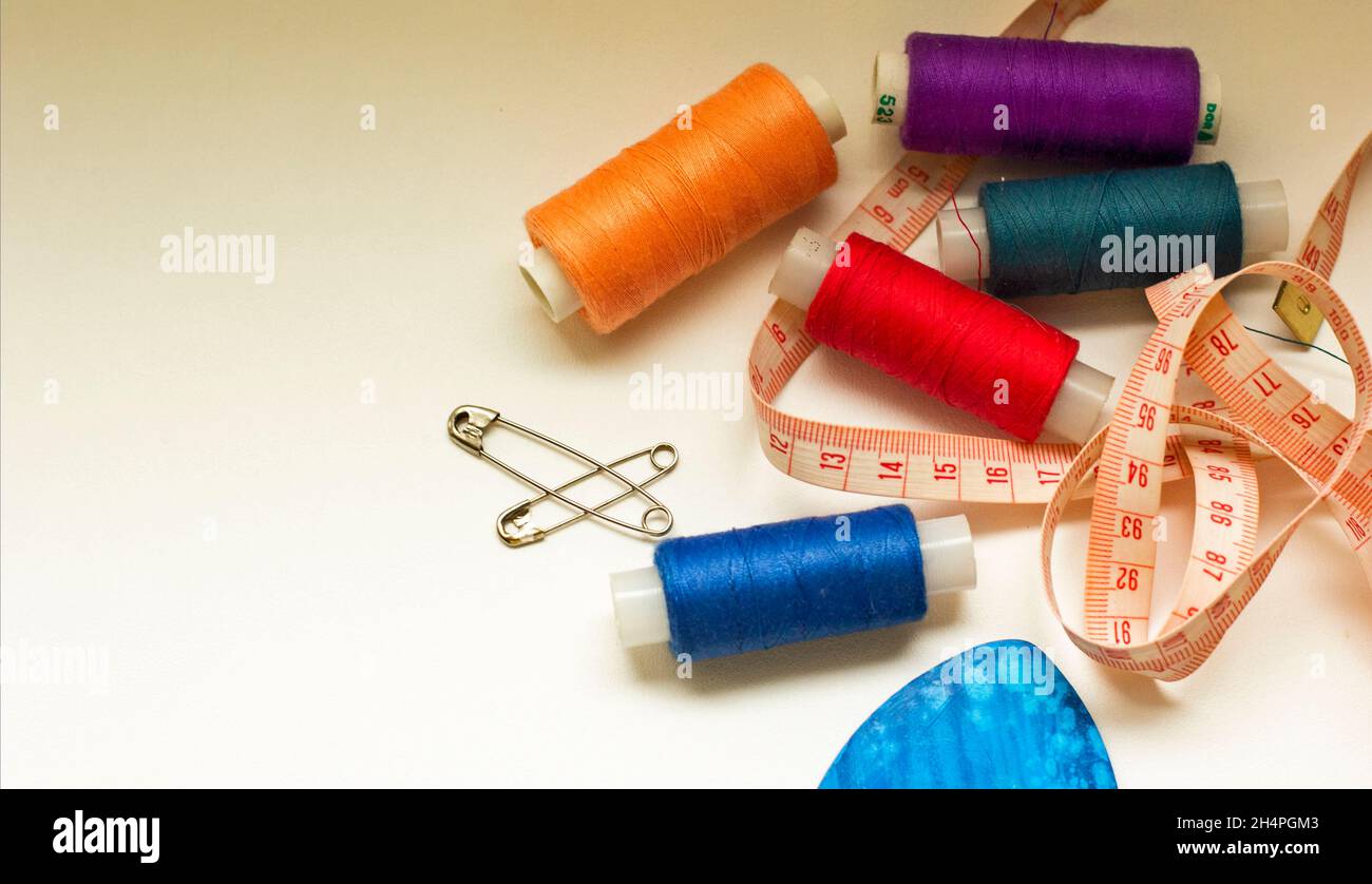 Composition with tailor needles and threads over white background Stock Photo