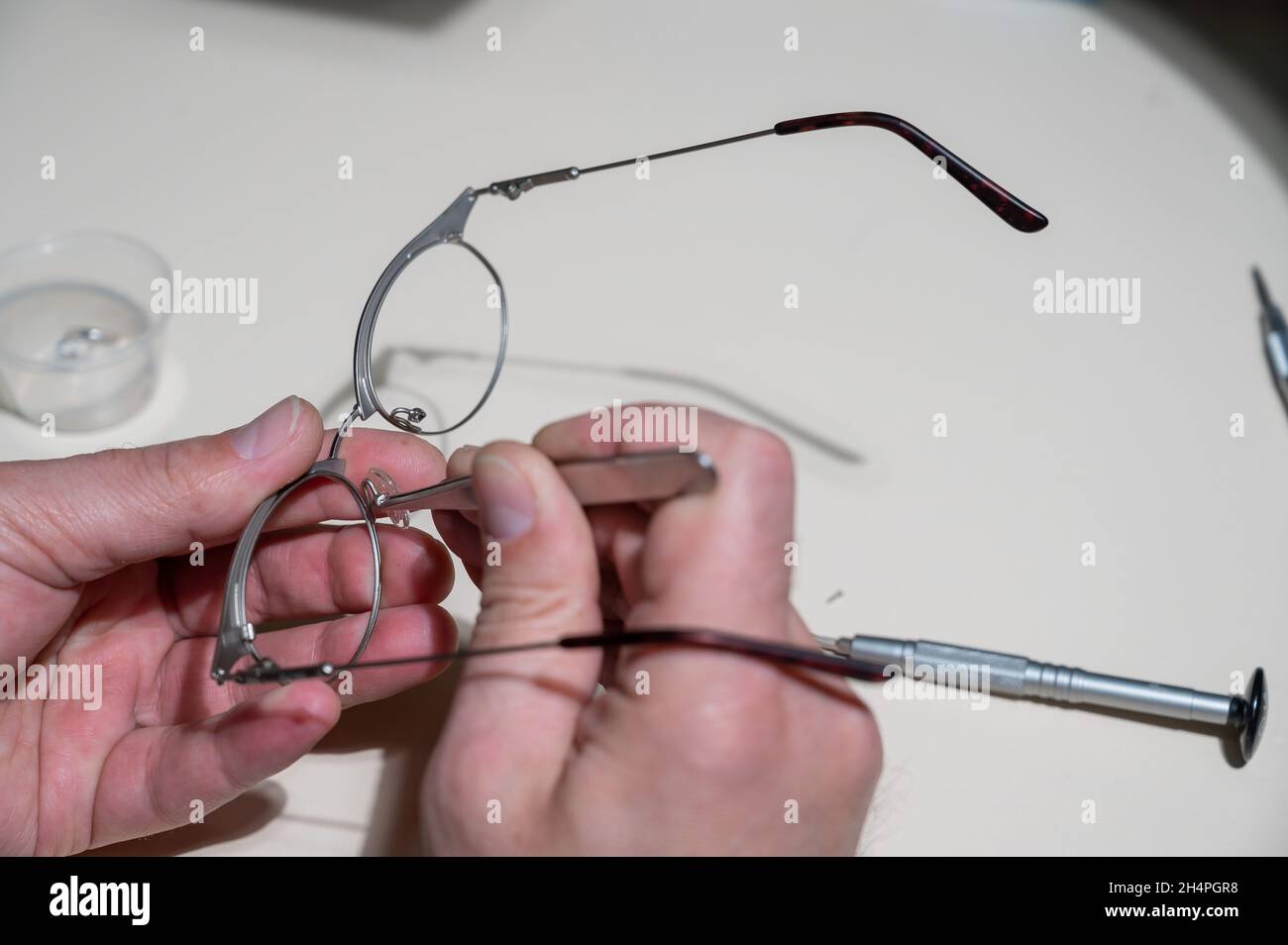 Installation of nose pads in glasses. A male technician repairs broken